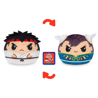 Two round Street Fighter Plushiverse Ryu and Chun Li 4" Reversible Plushies with serious facial expressions are depicted. One stuffed toy has a martial arts outfit and headband, while the other is dressed in a blue and gold outfit with feathers. A game box is in between them, adding to the collectible charm.