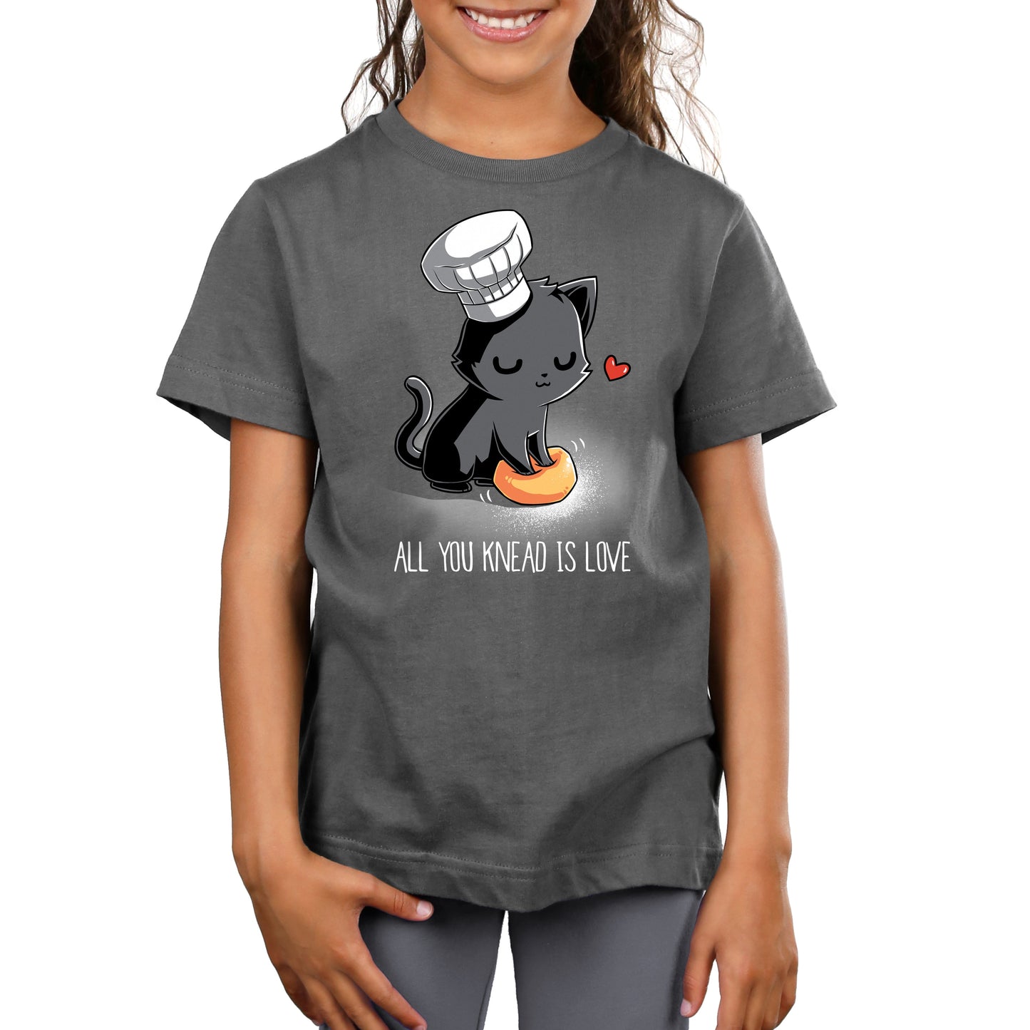 Premium Cotton T-shirt_A cartoon black cat wearing a chef's hat kneads a dough ball, with a red heart above its head, on this unisex tee. Caption reads: "All You Knead Is Love". Made of super soft ringspun cotton, this charcoal gray apparel called "All You Knead Is Love" by monsterdigital is perfect for cat lovers and baking enthusiasts alike.