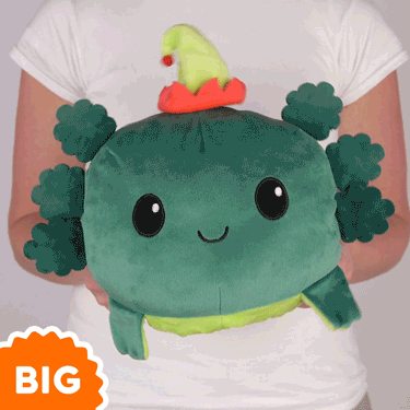 A woman is holding a green TeeTurtle Big Reversible Axolotl Plushie.