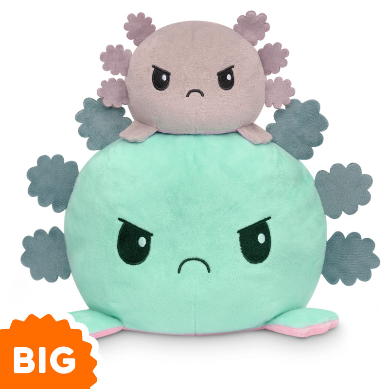 A Big Reversible Axolotl Plushie from TeeTurtle expresses emotions while stacked on top of another plush toy.