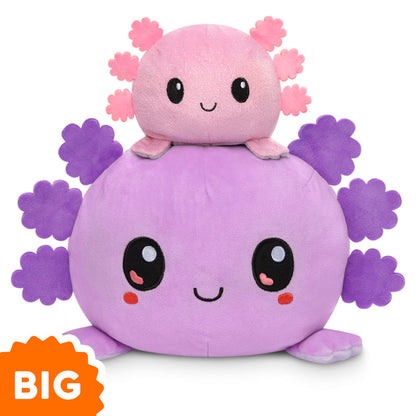 A Big Reversible Axolotl Plushie by TeeTurtle sitting on top of each other in pink and purple.