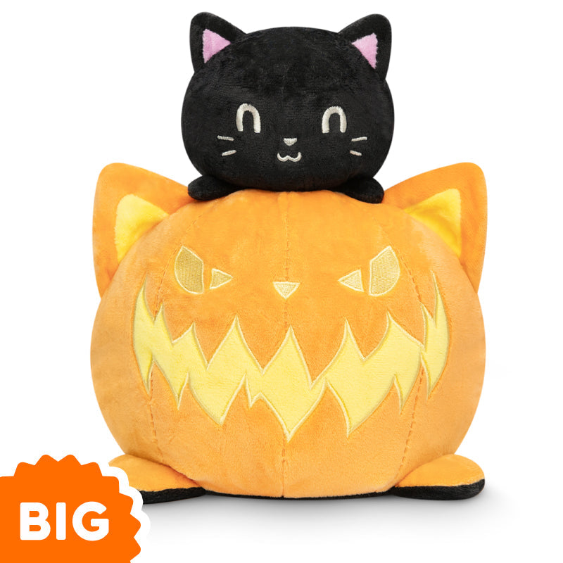 A Big Reversible Cat Plushie by TeeTurtle sits on top of a pumpkin, exuding mood.