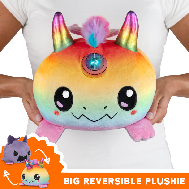 A woman is holding a Big Reversible Dragoncorn & Dragon TeeTurtle plushie.