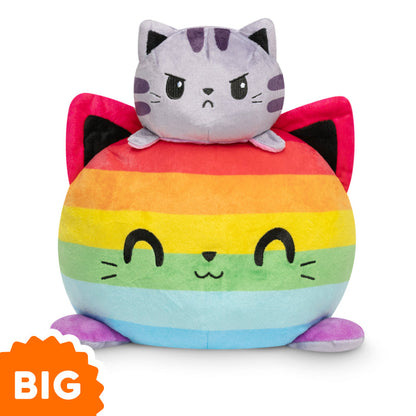 A Big Reversible Cat Plushie by TeeTurtle is sitting on top of a rainbow ball.