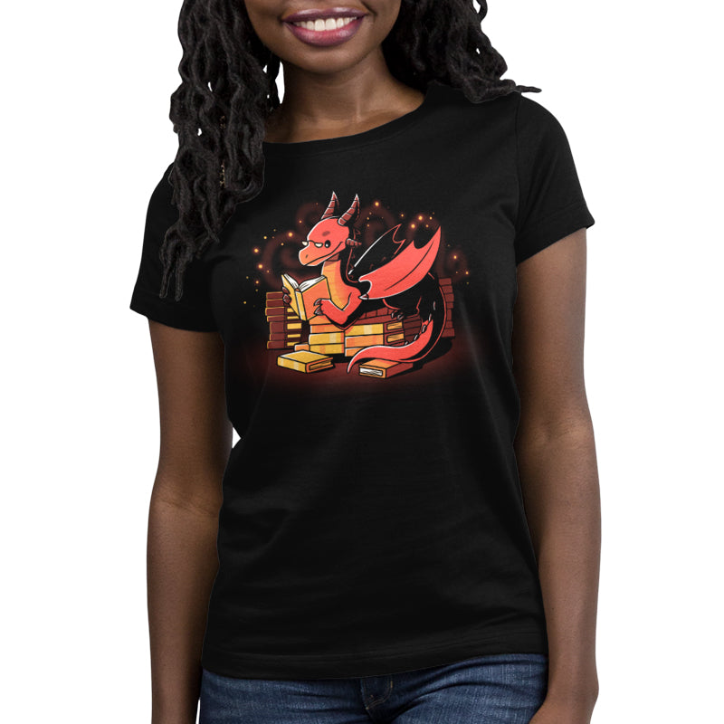 Premium Cotton T-shirt _TeeTurtle Book Hoarder black t-shirt featuring a red dragon with horns and wings, reading a book while sitting among piles of books against a dark background with glowing embers.