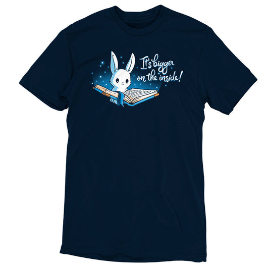 Premium Cotton T-shirt_Teeturtle Books are Bigger on the Inside Navy Blue t-shirt featuring a white rabbit reading a book from which light and sparkles are coming out with a blue ribbon bookmark marking the page with the text 