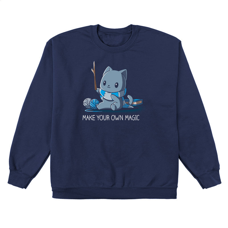 Crew Neck Sweatshirt_Teeturtle Make Your Own Magic Navy Blue Featuring a gray cat sitting in front of a book next to yarn with a wand-like stick and a crafted scarf with the text 'Make Your Own Magic' below.