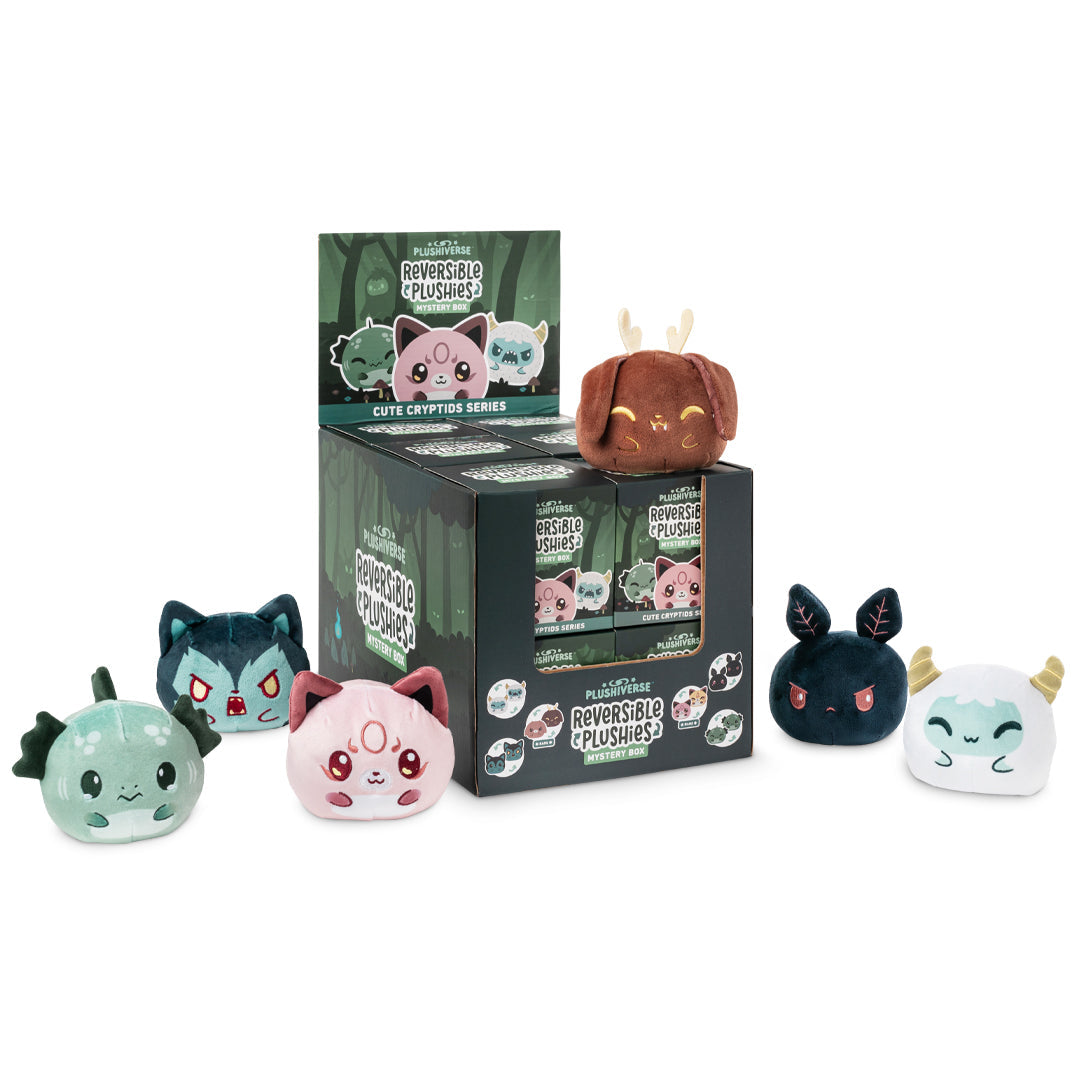 Display with Plushiverse Myths and Cryptids Reversible Plushie Mystery Boxes from TeeTurtle in various designs, including a snail and mythical creatures, next to their packaging.