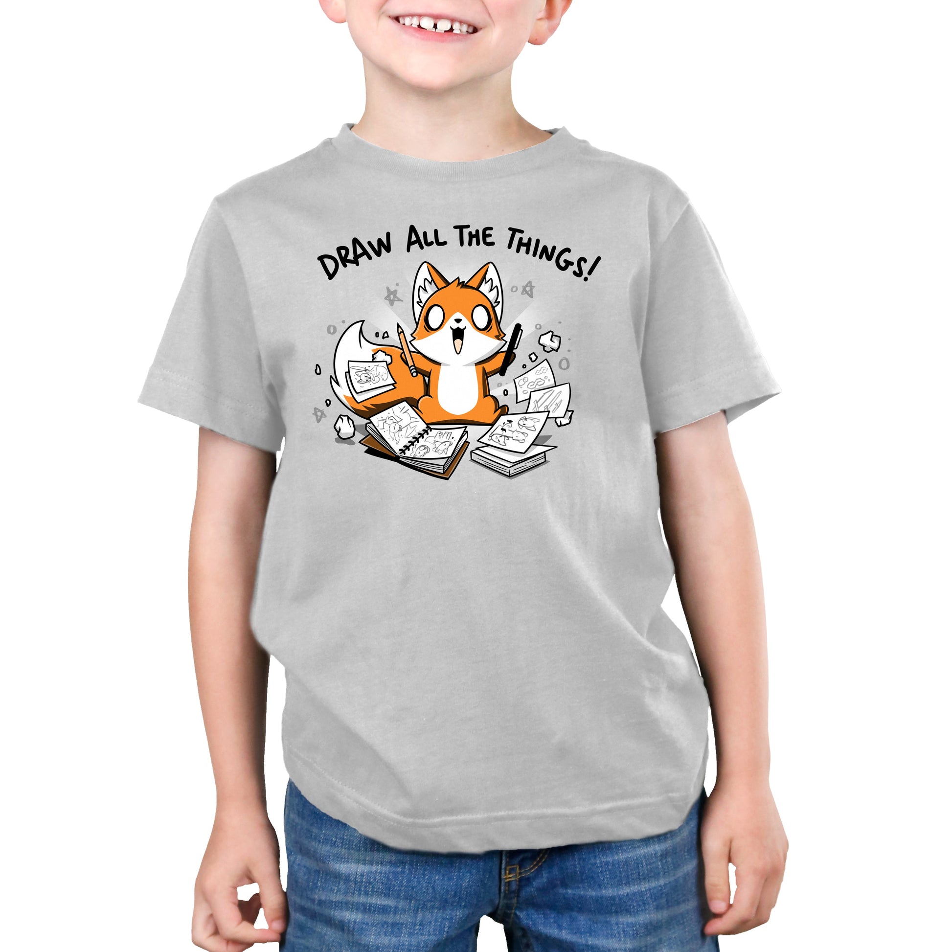 Premium Cotton T-shirt_A cartoon fox enthusiastically holding drawing tools, surrounded by sketchbooks with various drawings. Text above reads "Draw All The Things!" This monsterdigital original Draw all the Things! is crafted from super soft ringspun cotton for ultimate comfort.