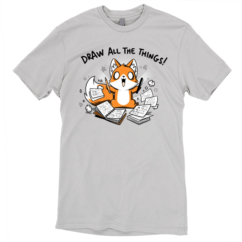 Premium Cotton T-shirt_A cartoon fox enthusiastically holding drawing tools, surrounded by sketchbooks with various drawings. Text above reads "Draw All The Things!" This monsterdigital original Draw all the Things! is crafted from super soft ringspun cotton for ultimate comfort.