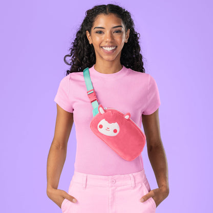 A woman wearing a TeeTurtle Plushiverse Cotton Candy Sheep Plushie Fanny Pack with an adjustable strap.