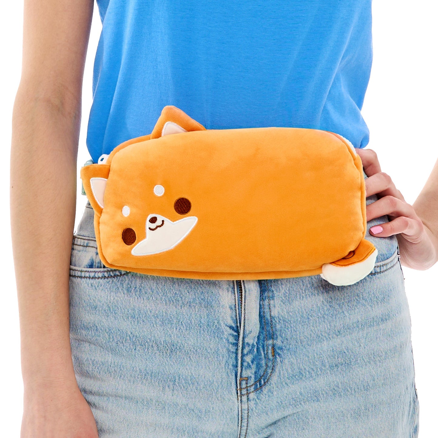 A person holding a TeeTurtle Plushiverse Super Shiba Plushie Fanny Pack against their hip.