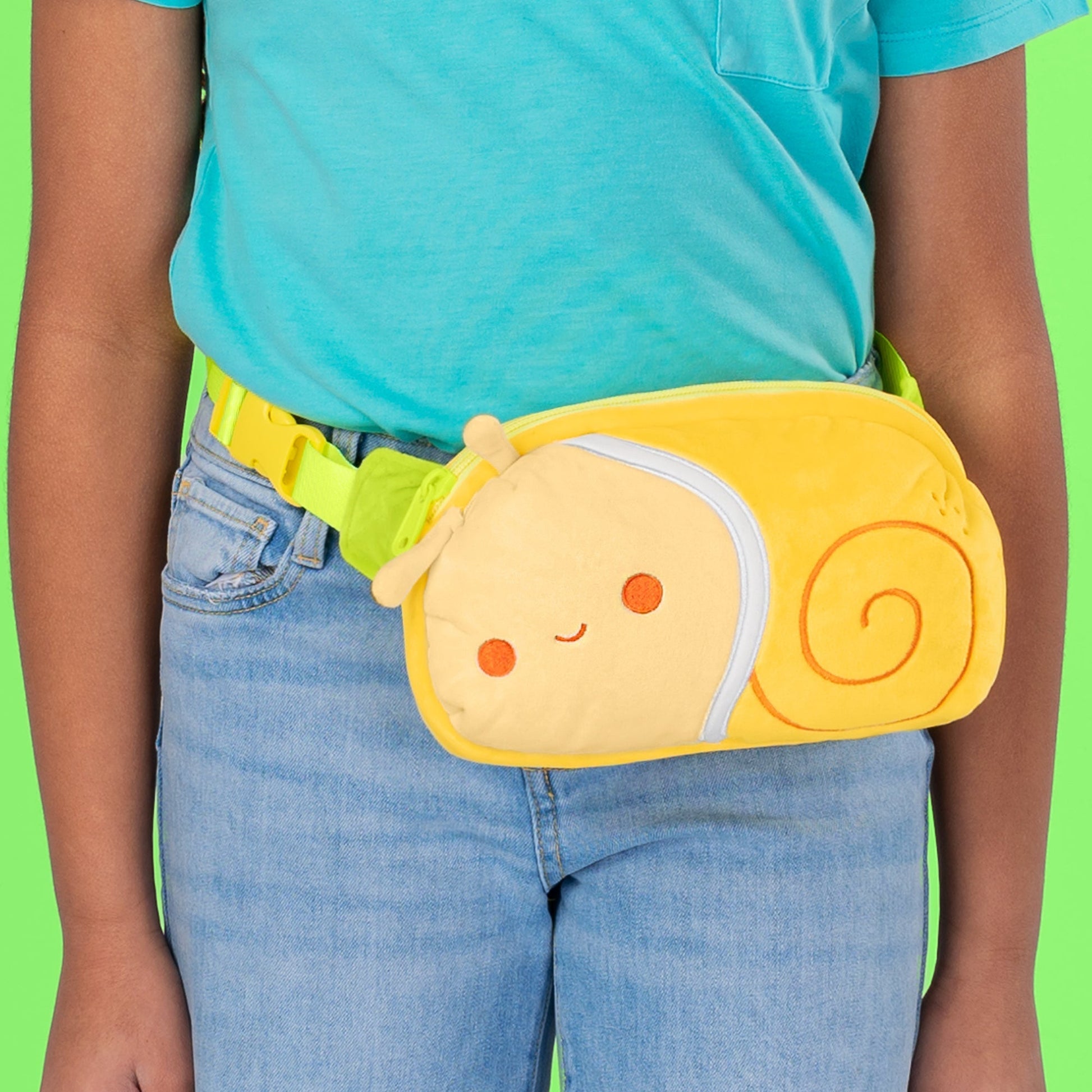 A child wearing a TeeTurtle Plushiverse Swirly Snail Plushie Fanny Pack.