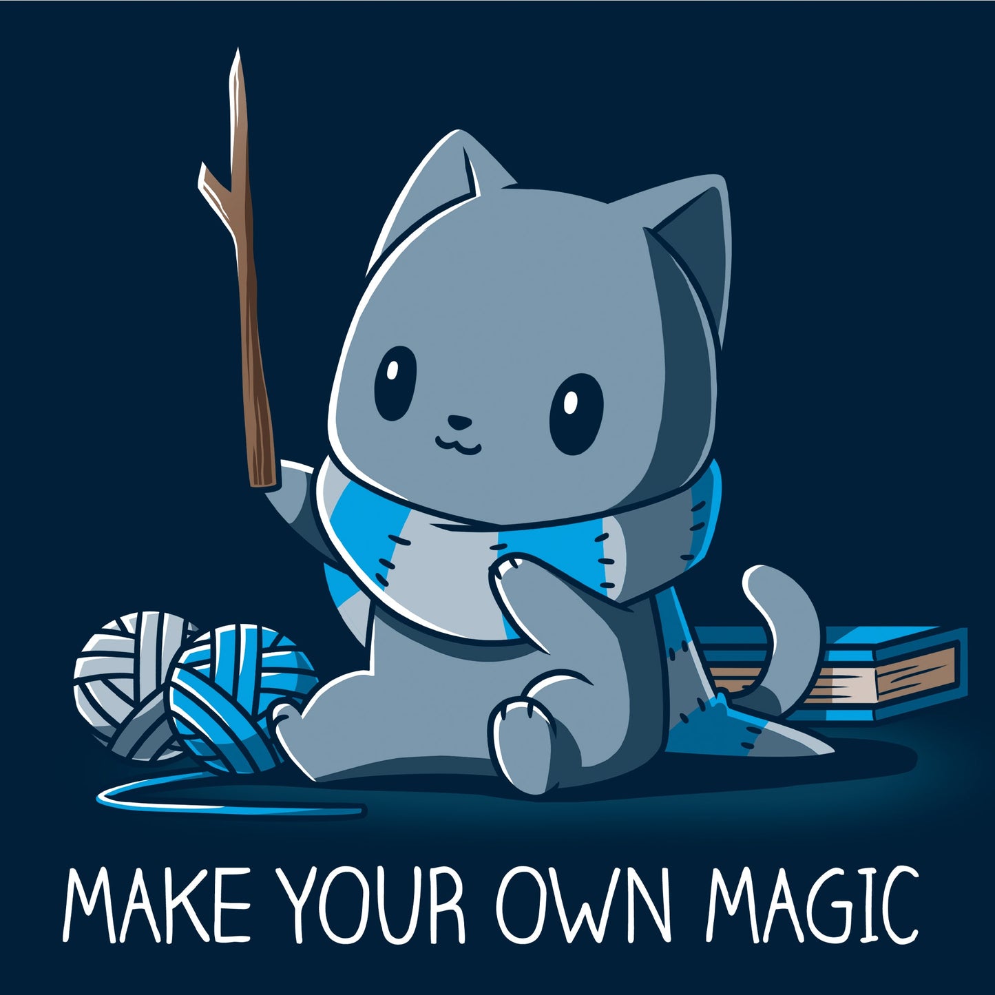 Long Sleeve T-shirt_Teeturtle Make Your Own Magic Navy Blue Featuring a gray cat sitting in front of a book next to yarn with a wand-like stick and a crafted scarf with the text 'Make Your Own Magic' below.