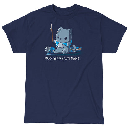 Classic Cotton T-shirt_Teeturtle Make Your Own Magic Navy Blue Featuring a gray cat sitting in front of a book next to yarn with a wand-like stick and a crafted scarf with the text 'Make Your Own Magic' below.