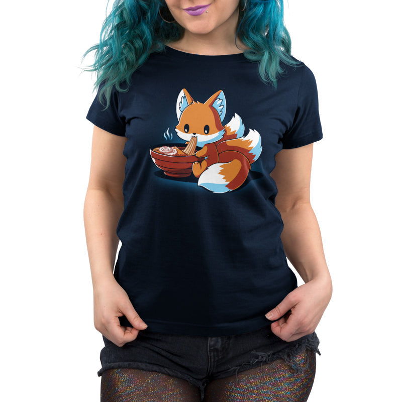 Premium Cotton T-shirt_A cartoon fox, known as the Ramen Kitsune, is sitting and eating noodles from a bowl, holding the noodles with its paws. Steam rises from the bowl. This charming scene is printed on a super soft ringspun cotton navy blue monsterdigital Ramen Kitsune apparel.