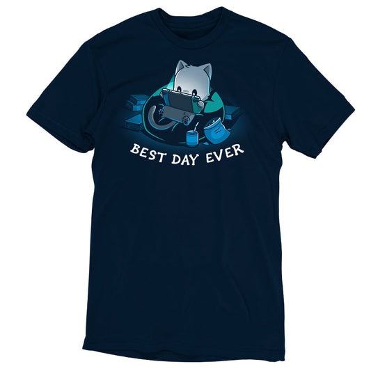 Premium Cotton T-shirt_TeeTurtle Best Day Ever navy blue t-shirt featuring an illustration of a cat sitting on a bean bag chair playing a portal video game surrounded by a mess of books and an open bag of chips and a can of soda with a straw. 