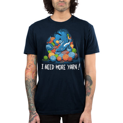 Premium Cotton T-shirt_TeeTurtle Yarn Hoarder navy blue t-shirt featuring a blue dragon sitting on top of a pile of multi-colored yarn balls. The words "I NEED MORE YARN!" are written underneath the illustration.