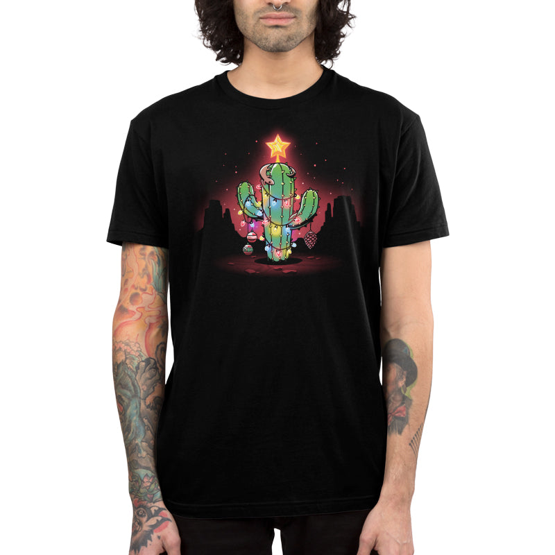 Premium Cotton T-shirt_TeeTurtle A Desert Christmas Black t-shirt featuring an artistic cactus with lights, ornaments, a star, and a gecko on top in front of a grand canyon inspired silhouetted background.