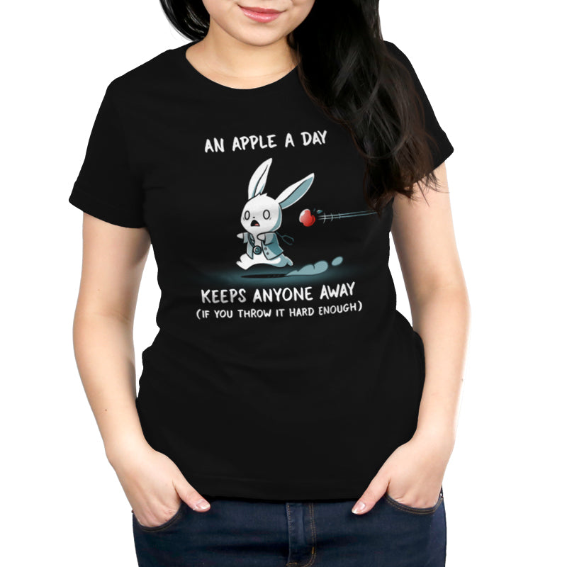 Premium Cotton T-shirt_TeeTurtle An Apple A Day Keeps Anyone Away black t-shirt featuring a rabbit, dressed in a doctor uniform, running away from a flying apple. Text above reads, "an apple a day keeps anyone away," and below, "(if you throw it hard enough)."