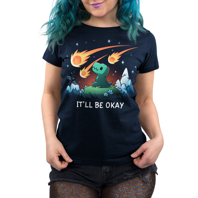 Premium Cotton T-shirt_TeeTurtle It'll Be Okay navy blue t-shirt featuring a green dinosaur who sits on a grassy hill with comet-like objects falling from the sky around them with the words "IT'LL BE OKAY" below them. 