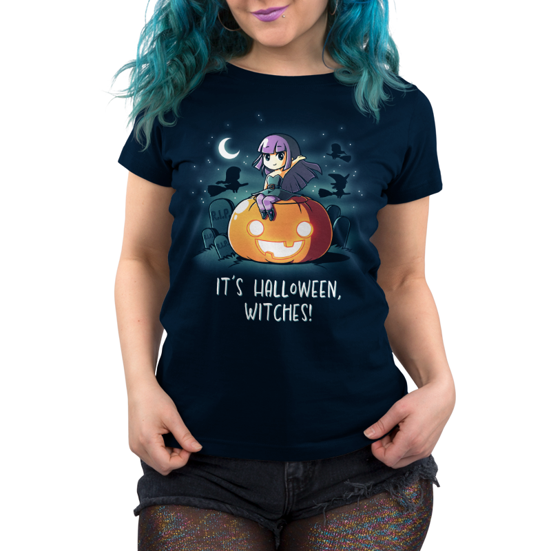 Premium Cotton T-shirt_TeeTurtle It's Halloween, Witches! navy blue t-shirt featuring an illustration of a witch with purple hair wearing a green dress with purple tights sitting on top of a large, smiling orange jack-o-lantern in a graveyard filled with tombstones that say R.I.P. The background features silhouettes of three black witches on broomsticks flying in the starry sky that features a quarter moon. "IT'S HALLOWEEN WITCHES!" is written underneath.