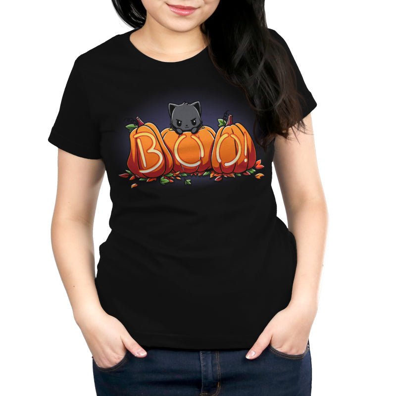 Premium Cotton T-shirt_TeeTurtle Pumpkin Kitty black t-shirt featuring a spooky black cat sitting behind three pumpkins that spell "BOO!" with glowing letters, surrounded by scattered leaves in Halloween fall colors. 