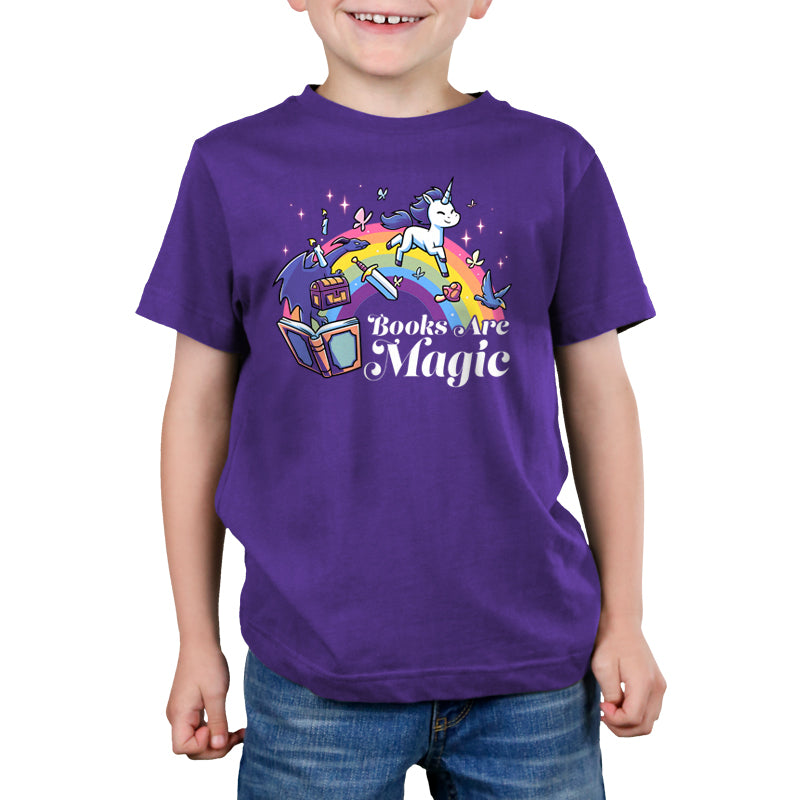 Premium Cotton T-shirt_TeeTurtle Books Are Magic(Unicorn) purple t-shirt featuring a flying unicorn, open book, rainbow, treasure chest, sword, and birds.