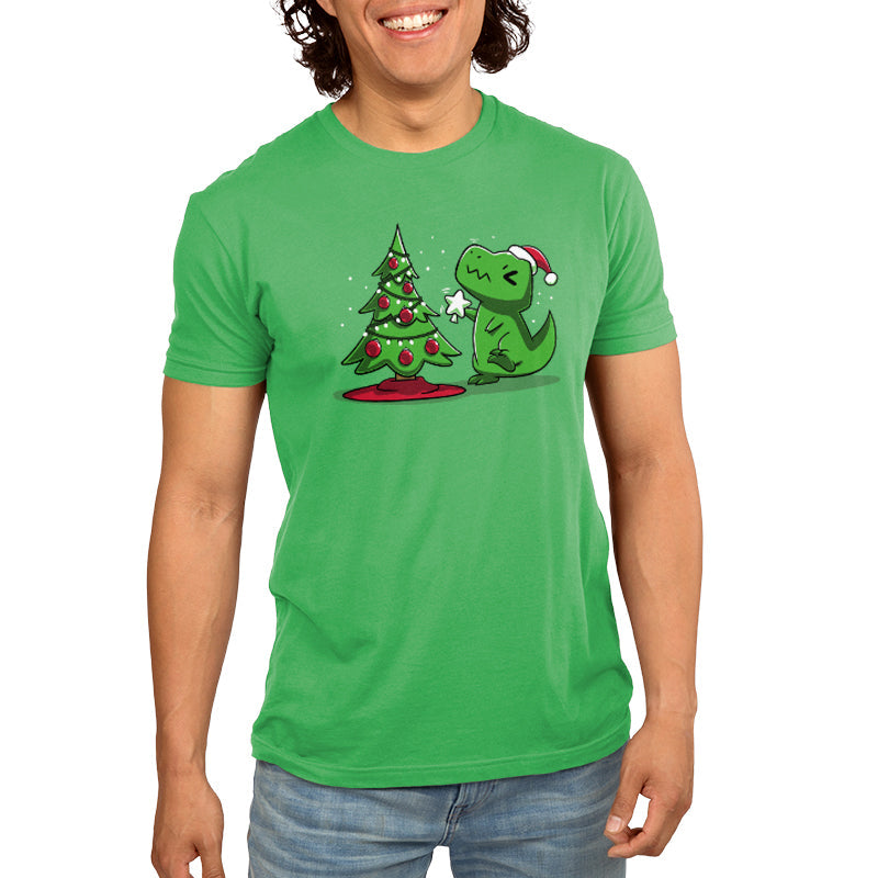 Premium Cotton T-shirt_TeeTurtle Christmas T-Rex apple green t-shirt featuring a cartoon dinosaur wearing a Santa hat placing a star atop a Christmas tree adorned with red baubles and lights. 