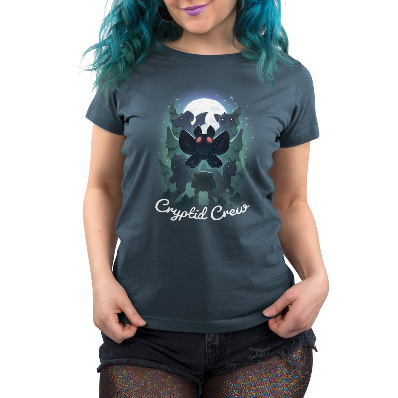 Premium Cotton T-shirt_TeeTurtle Cryptid Crew denim t-shirt featuring a whimsical illustration of six cartoon cryptids, including a mothman and a jackalope, in a forest with a full moon in the background. Text at the bottom reads "Cryptid Crew."