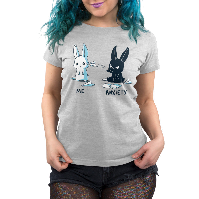 Premium Cotton T-shirt_TeeTurtle Me vs Anxiety silver gray t-shirt featuring an illustration of two cartoon bunnies. A white bunny is labeled "Me," and is looking annoyed while a paper airplane crashes into its face, while a black bunny labeled "Anxiety" aggressively throws paper planes at the other bunny. Paper planes are scattered on the ground around anxiety.