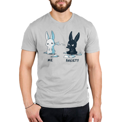 Premium Cotton T-shirt_TeeTurtle Me vs Anxiety silver gray t-shirt featuring an illustration of two cartoon bunnies. A white bunny is labeled "Me," and is looking annoyed while a paper airplane crashes into its face, while a black bunny labeled "Anxiety" aggressively throws paper planes at the other bunny. Paper planes are scattered on the ground around anxiety.