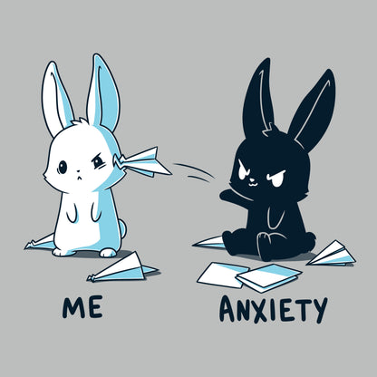 Premium Cotton T-shirt_TeeTurtle Me vs Anxiety silver gray t-shirt featuring an illustration of two cartoon bunnies. A white bunny is labeled "Me," and is looking annoyed while a paper airplane crashes into its face, while a black bunny labeled "Anxiety" aggressively throws paper planes at the other bunny. Paper planes are scattered on the ground around anxiety. 