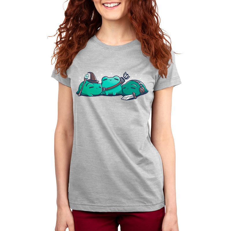 Premium Cotton T-shirt - A person wearing a gray kids' apparel featuring a cartoon graphic of three green characters, two sleeping and one holding a fork. The individual has long, wavy red hair and is smiling. The apparel is the RPG Frogs by monsterdigital.