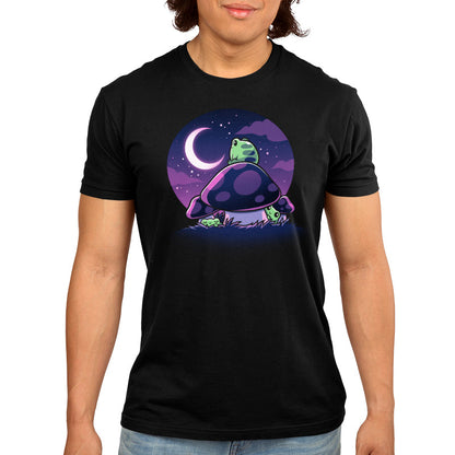 Premium Cotton T-shirt_TeeTurtle Twilight Toadstools black t-shirt featuring an illustration of a green frog sitting on top of a mushroom gazing up at the stars and a crescent moon in a violet-purple sky. There are two more green frogs underneath the mushroom cap, and two additional mushrooms on the side.