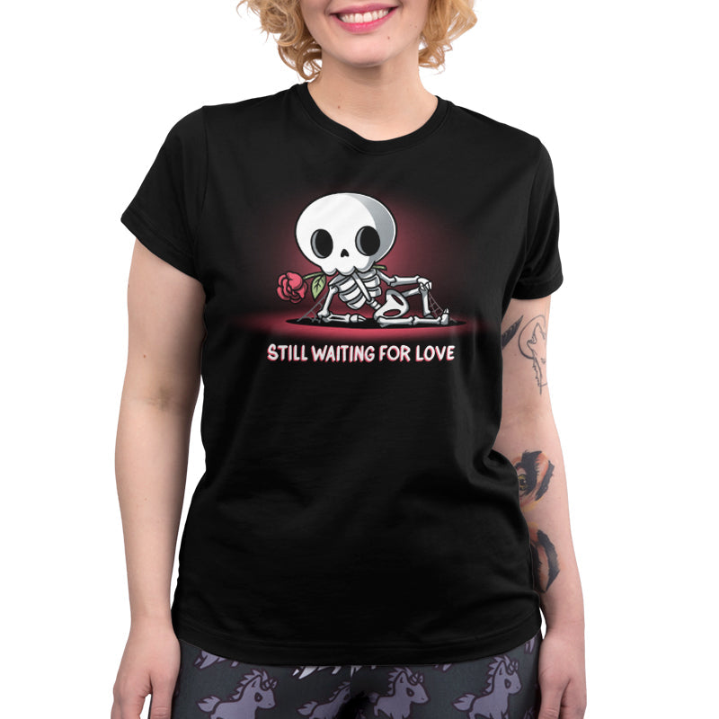 Premium Cotton T-shirt_TeeTurtle Still Waiting For Love black t-shirt featuring a skeleton holding a red rose and lying on the ground with the text "Still Waiting for Love."