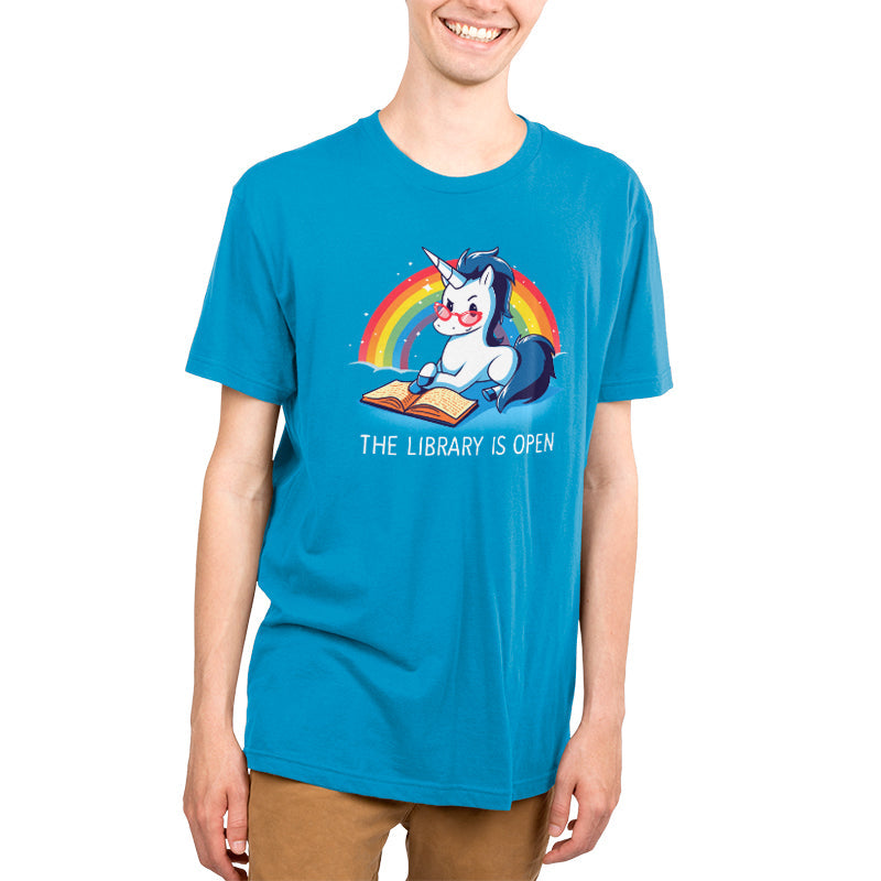 Premium Cotton T-shirt_TeeTurtle The Library is Open cobalt blue t-shirt featuring a unicorn with glasses reading a book against a rainbow backdrop.