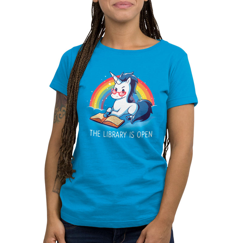 Premium Cotton T-shirt_TeeTurtle The Library is Open cobalt blue t-shirt featuring a unicorn with glasses reading a book against a rainbow backdrop.