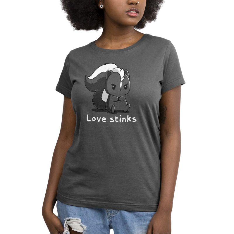 Premium Cotton T-shirt_A black and white cartoon skunk sits with a grumpy expression on this Love Stinks apparel by monsterdigital, made from super soft ringspun cotton. The phrase "Love stinks" is written below in white text, set against a charcoal gray apparelbackground.