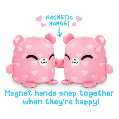 The TeeTurtle Reversible Bear Plushmate is a pink teddy bear with magnetic hands. This plush toy has the unique feature of its magnetic hands snapping together when happy.