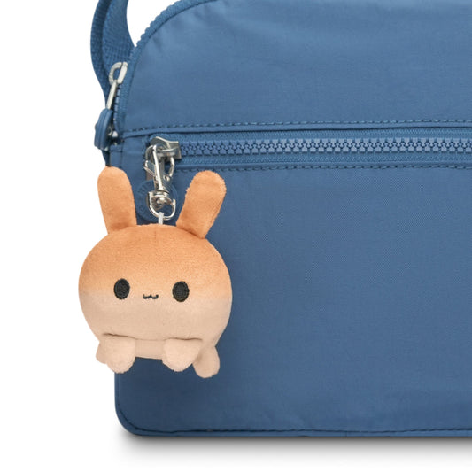 A portable blue purse with a TeeTurtle Bunny Plushie Charm Keychain hanging from it.