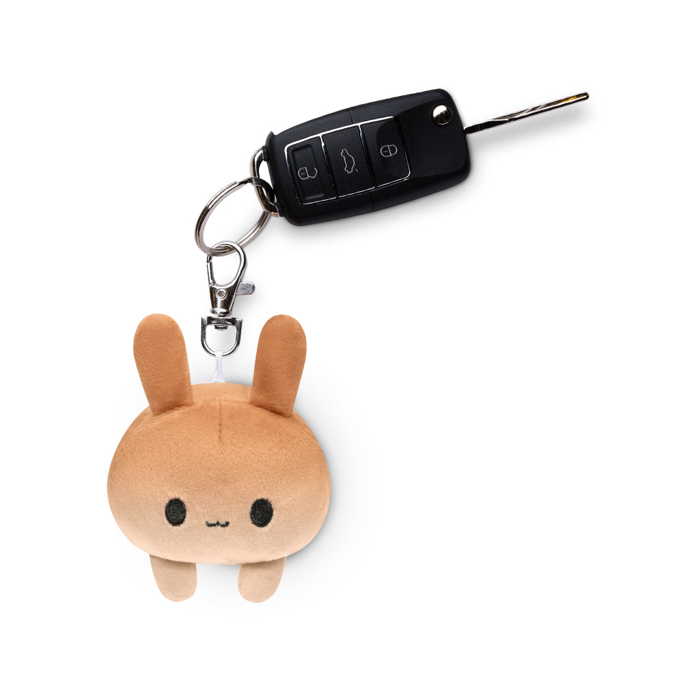 A portable Bunny Plushie Charm Keychain featuring a bunny plushie with a car key attached, made by TeeTurtle.