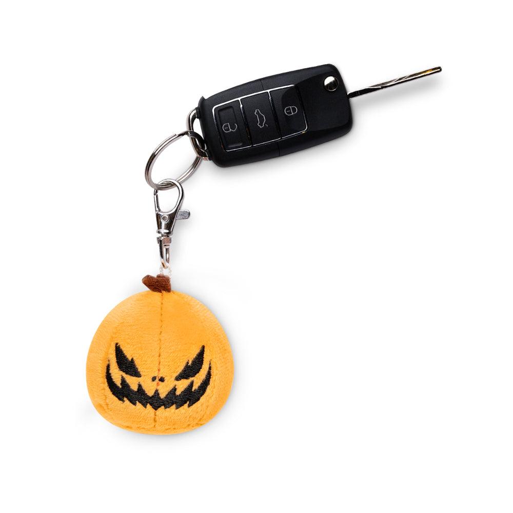 A TeeTurtle Jack-o-Lantern Plushie Charm Keychain with a jack o lantern clip.