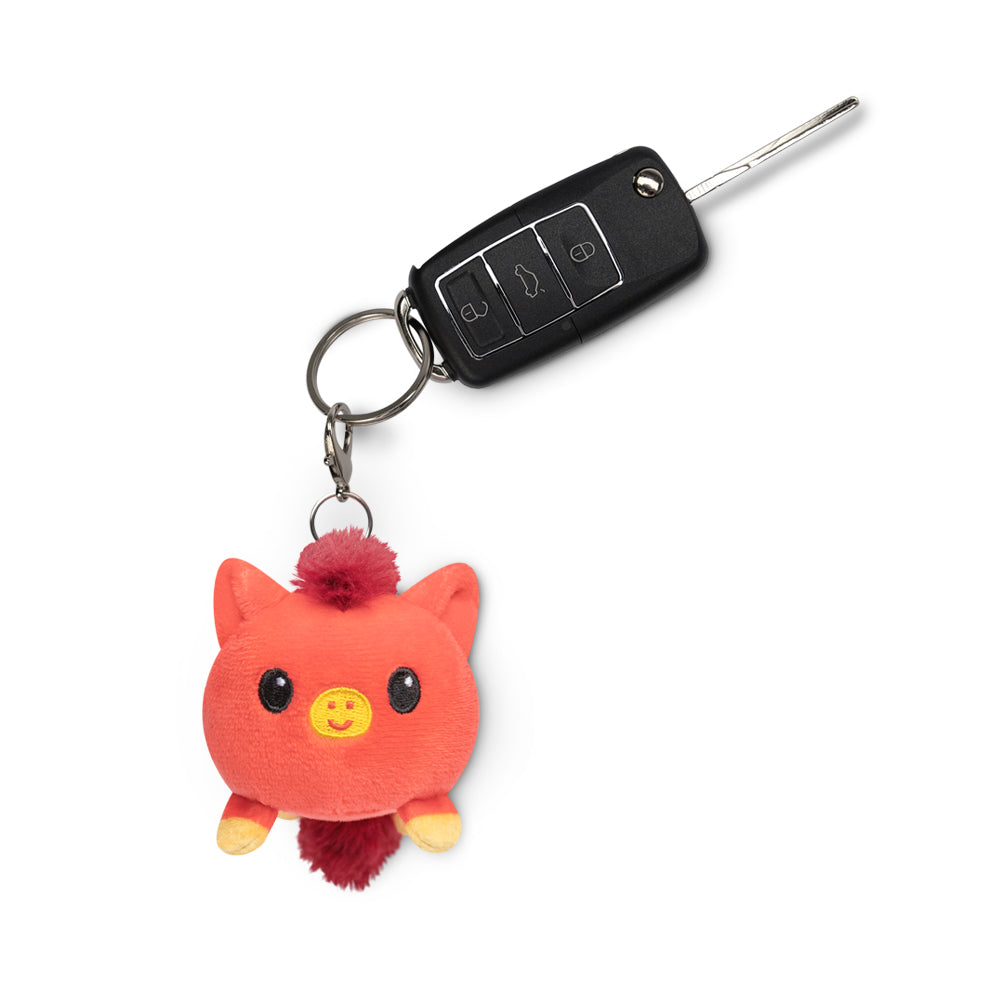 A portable TeeTurtle Lunar New Year Horse Plushie Charm Keychain featuring a stuffed pig.