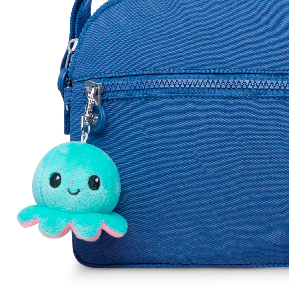 A blue purse with a portable Octopus Plushie Charm Keychain from TeeTurtle.