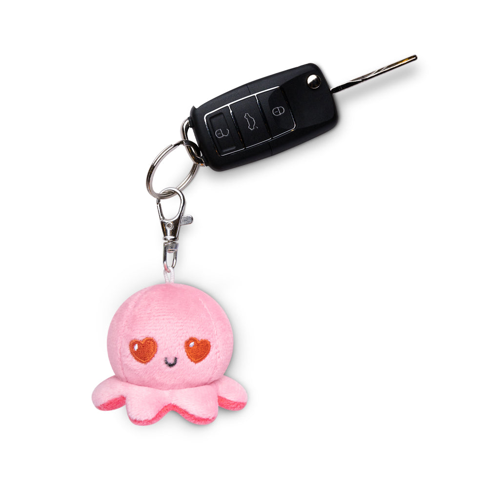 A portable pink Octopus Plushie Charm Keychain by TeeTurtle is attached to a car key.