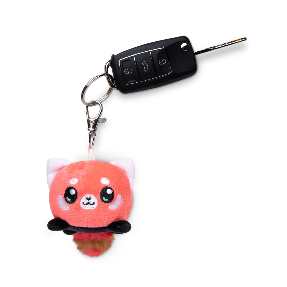 A TeeTurtle Red Panda Plushie Charm Keychain is attached to a car key.