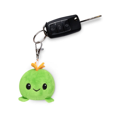 A green Stego Plushie Charm Keychain by TeeTurtle, perfect as a charm for your backpack.