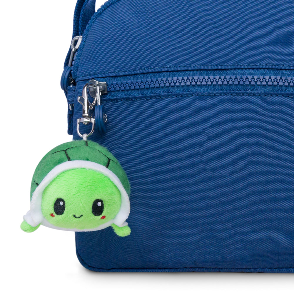 A TeeTurtle Turtle Plushie Charm Keychain in a blue purse.