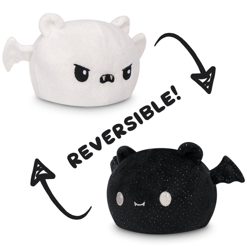 Two black and white TeeTurtle reversible bat plushies.